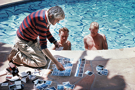 Michael Childers, David Hockney, poolside in Los Angeles, with polaroid’s of David Stolts and Ian Falconer, circa 1978. Image: © Michael Childers/Corbis via Getty Images